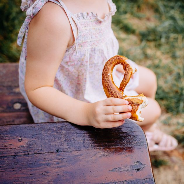 Enfant mange un bretzel au Biergarten